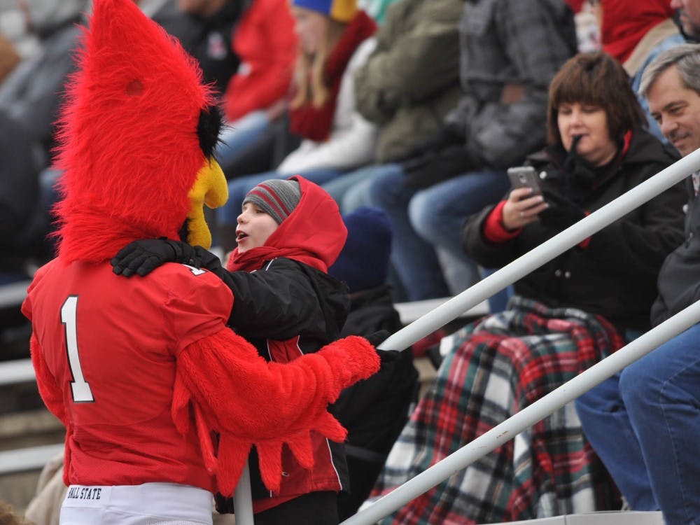 Charlie Cardinal hugs a child during the game against Toledo on Oct. 3 at Scheumann Stadium. Charlie Cardinal interacted with fans throughout the competition. DN PHOTO JASON CONERLY