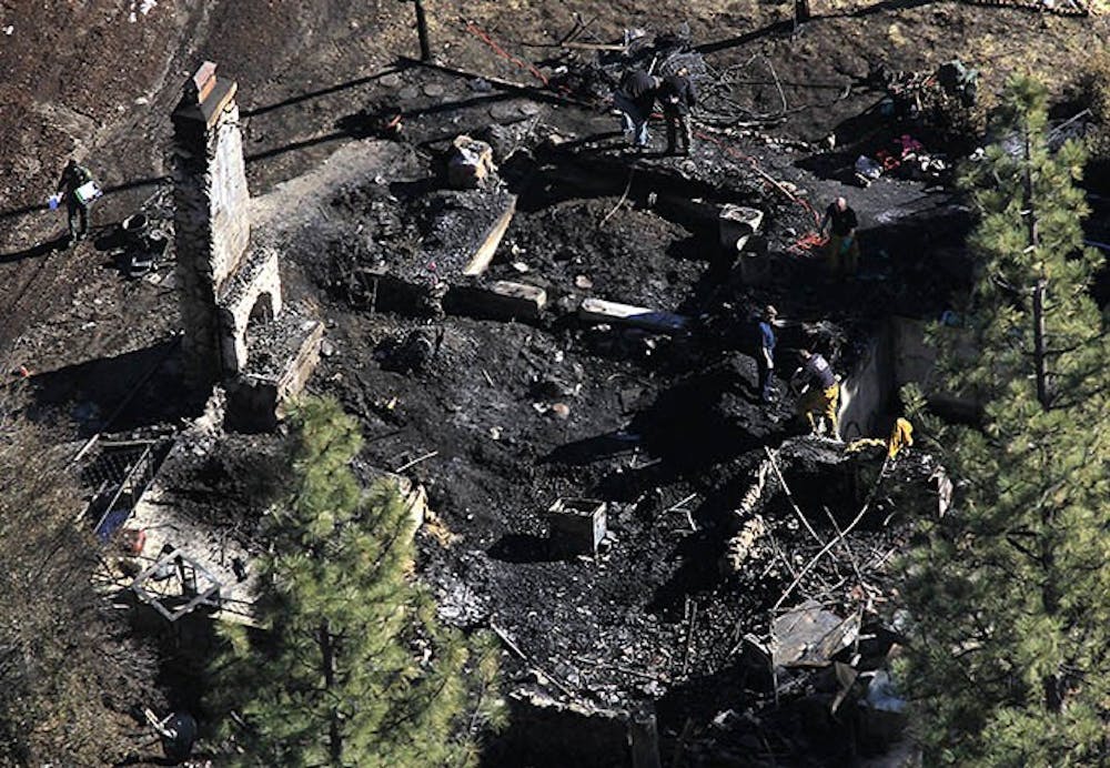 Investigators process the scene and identify the human remains found in the charred cabin on Wednesday, February 13, 2013, where fugitive ex–cop Christopher Dorner was believed to have been holed up after trading gunfire overnight with officers. (Brian Vander Brug/Los Angeles Times/MCT)