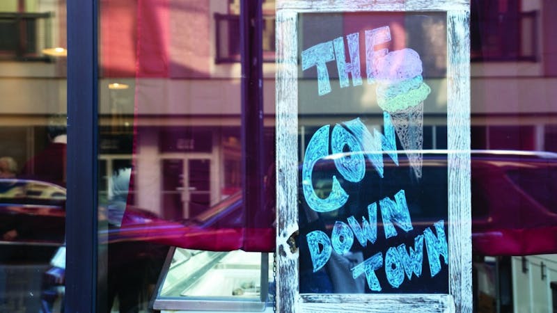 A sign in the window of The Barking Cow displays the ice cream shop’s nickname, “The Cow Downtown.” Manager Danielle Woodson gave this nickname to The Barking Cow because in Gaston, locals call the ice cream shop, “The Cow.” Pauleina Brunnemer, DN