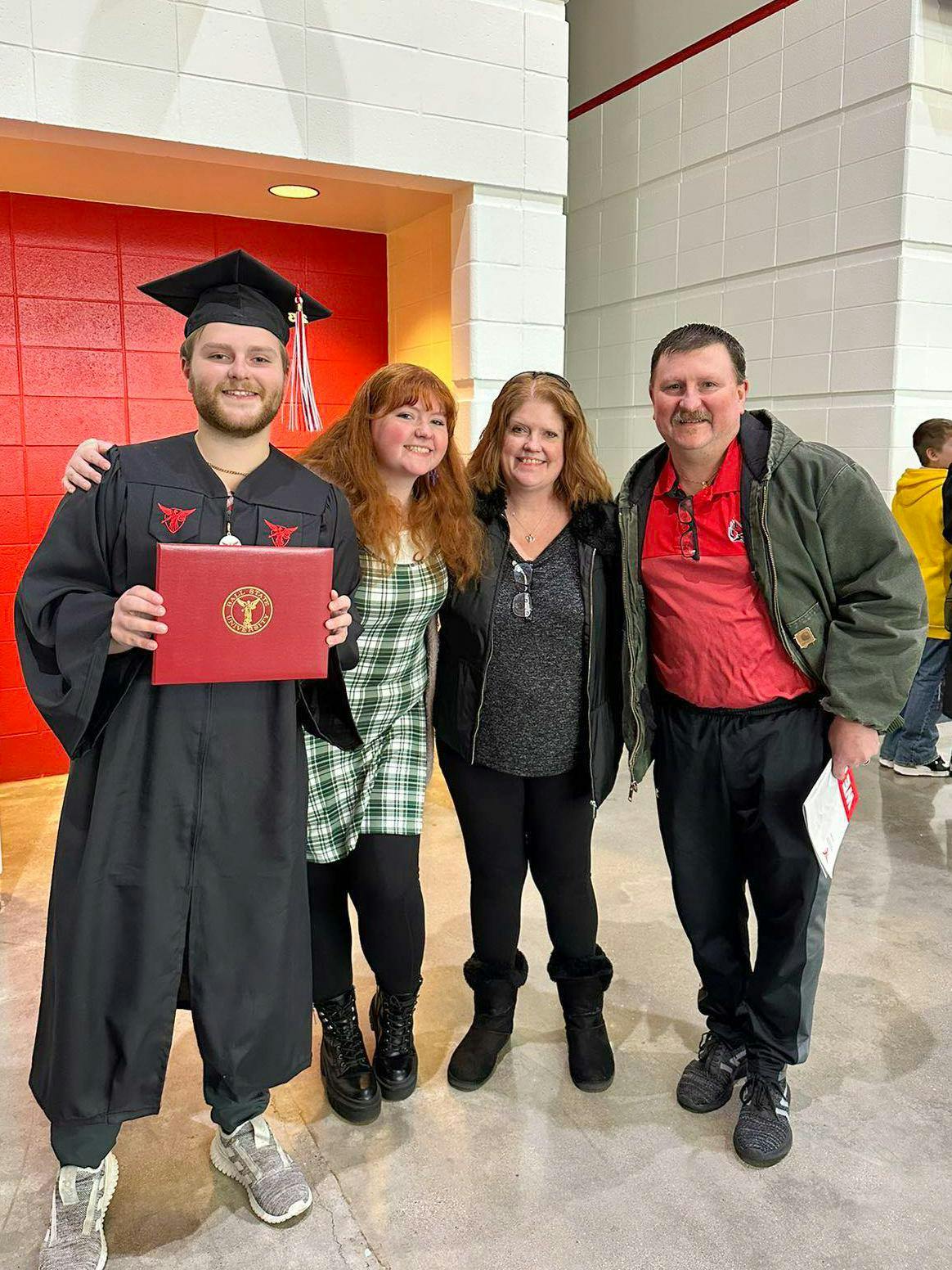 From left, brother Andrew Braddy, Meghan Braddy, mother Amy Braddy and father Gordon Braddy pose together after Andrew’s December 2023 graduation ceremony in Worthen Arena at Ball State University. Photo Provided, Amy Braddy
