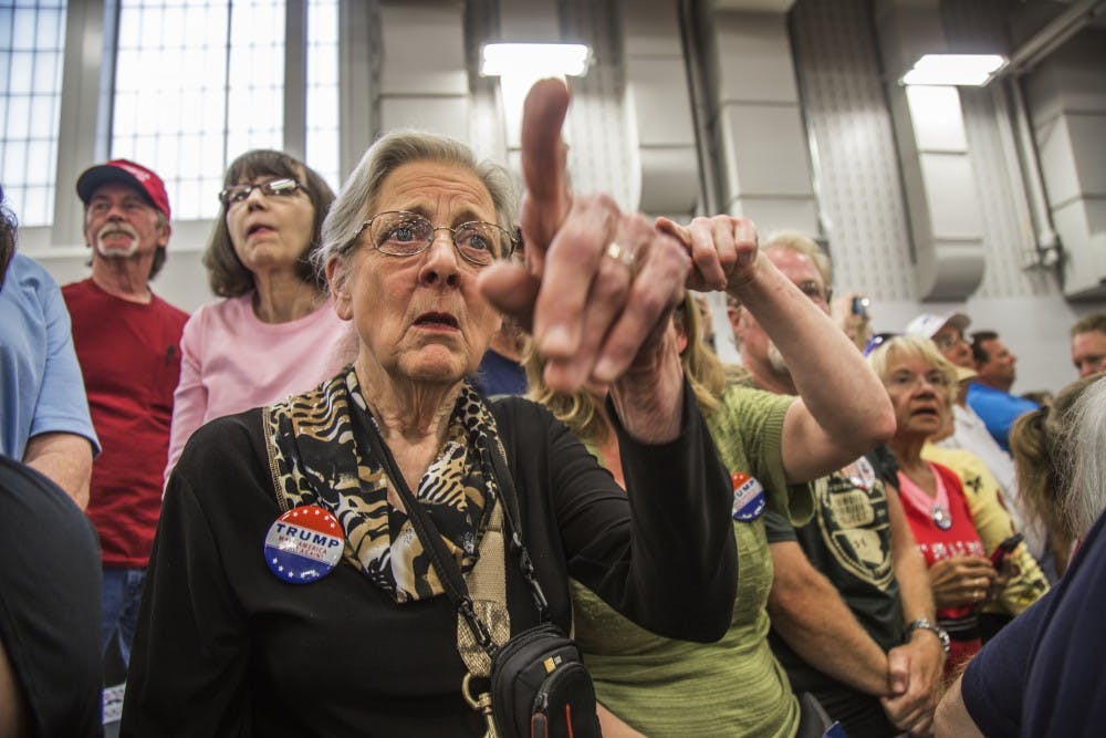 The crowd starts chanting in tandem while pointing at the protestors being escorted out of the field house. DN PHOTO TRENT SCROGGINS 