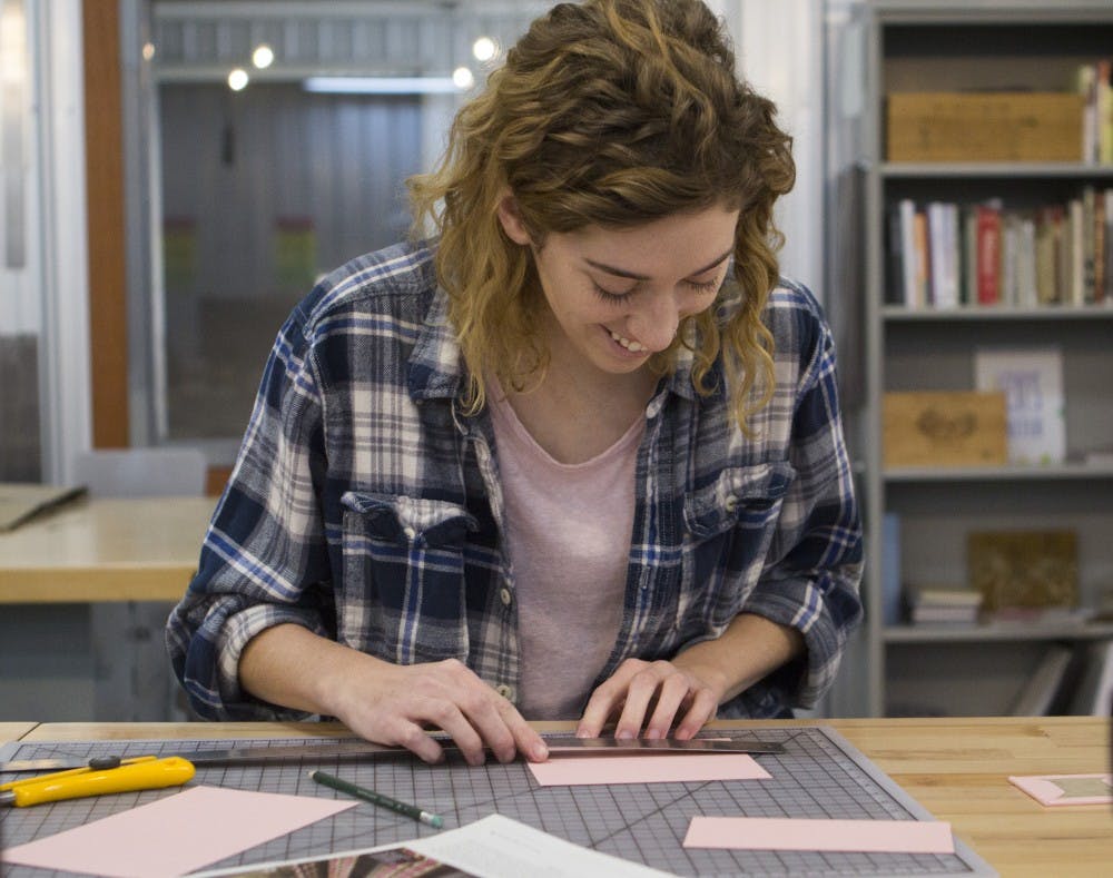 Gipson Schabel, a senior actuarial science major, works on making miniature books at the Book Arts Collaborative in downtown Muncie. Emma Rogers // DN