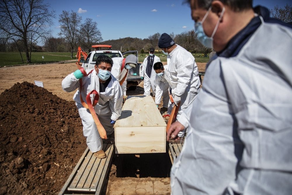In this April 6, 2020 photo, gravediggers lower the casket of someone who died of coronavirus at the Hebrew Free Burial Association&#x27;s cemetery in the Staten Island borough of New York. (AP Photo/David Goldman, File)