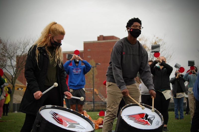 Junior music education major AnnaMarie Kelly (left) plays the bass drum during a Ball State Pride of Mid-America (POMA) Marching Band rehearsal this semester on LaFollette Field. The POMA Marching Band was split into three bands to ensure social distancing during rehearsals. Bethany Sloniker, Photo Courtesy