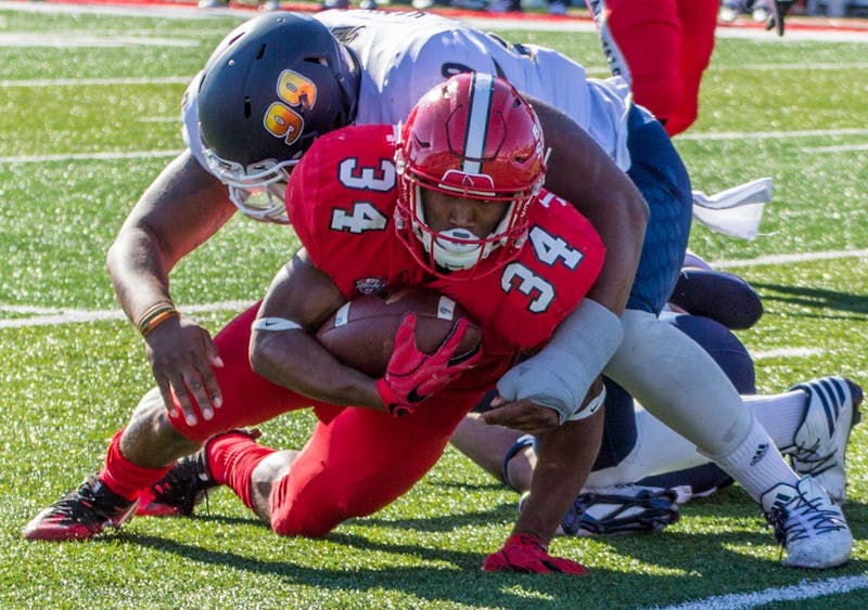 Ball State's running back James Gilbert is tackled by an Akron player during the game on Oct. 22 in Scheumann Stadium. The Cardinals lost 25 to 35. Grace Ramey, DN