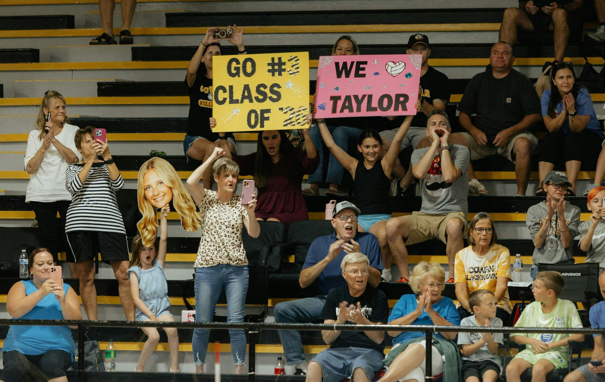 Senior Taylor Young’s family cheers as she is announced for senior night. They then continued to cheer with their signs the rest of the night at Cowan Jr.Sr high school on Sept. 30. (Photo by Kaylee Kern) 