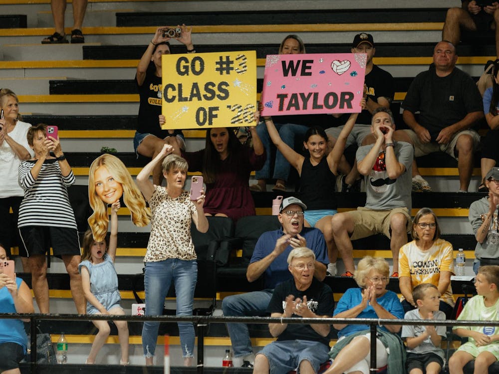 Senior Taylor Young’s family cheers as she is announced for senior night. They then continued to cheer with their signs the rest of the night at Cowan Jr.Sr high school on Sept. 30. (Photo by Kaylee Kern)