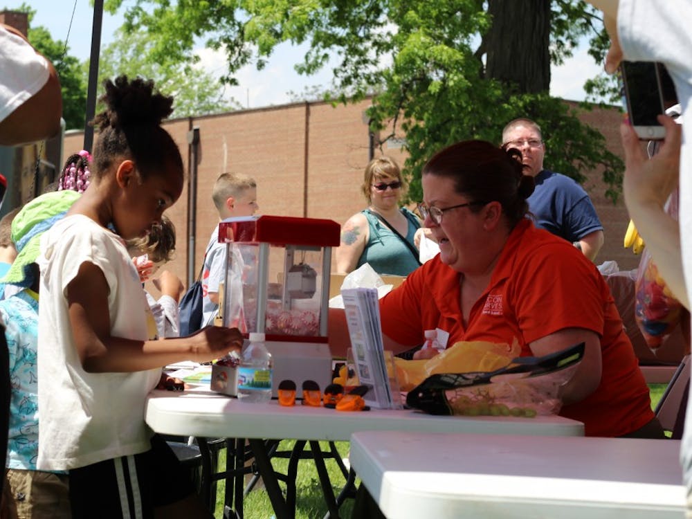 Stacey Ream-Britton, research development coach for Second Harvest Food Bank, works a her station as a participant stands by at Ball State's Community Campus Experience event May 18, 2019, at Heekin Park. Second Harvest distributed fruits to those in attendance. Britney S. Kendrick, DN