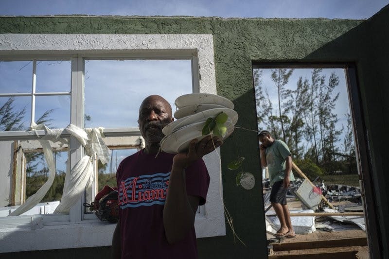 Mister Bolter recovers dishes from his son's home, destroyed by Hurricane Dorian in Pine Bay, near Freeport, Bahamas, Wednesday, Sept. 4, 2019. Rescuers trying to reach drenched and stunned victims in the Bahamas fanned out across a blasted landscape of smashed and flooded homes Wednesday, while disaster relief organizations rushed to bring in food and medicine. (AP Photo/Ramon Espinosa)