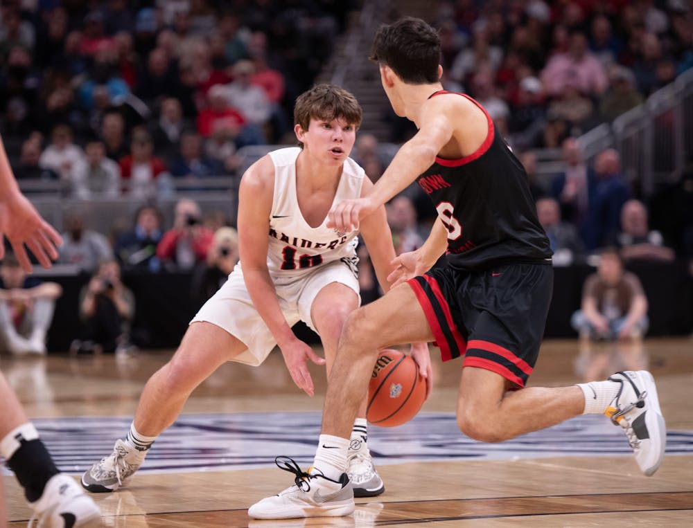 <p>Junior guard Nate Luce dribbles the ball against Brownstown Central March 30 at IHSAA State Finals at Gainbridge Fieldhouse in Indianapolis. Luce had two rebounds in the game. Andrew Berger, DN</p>