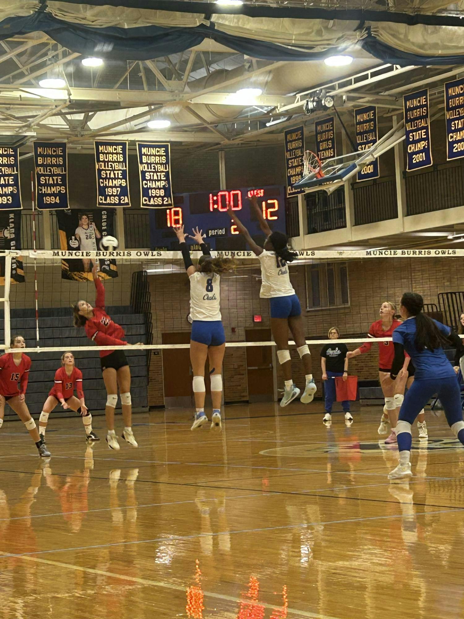 Burris players jump up to block an incoming ball at the net. The Owls swept Eastbrook in straight sets, 25–11, 25–20 and 25–21. PHOTO BY BREANNE BUTLER