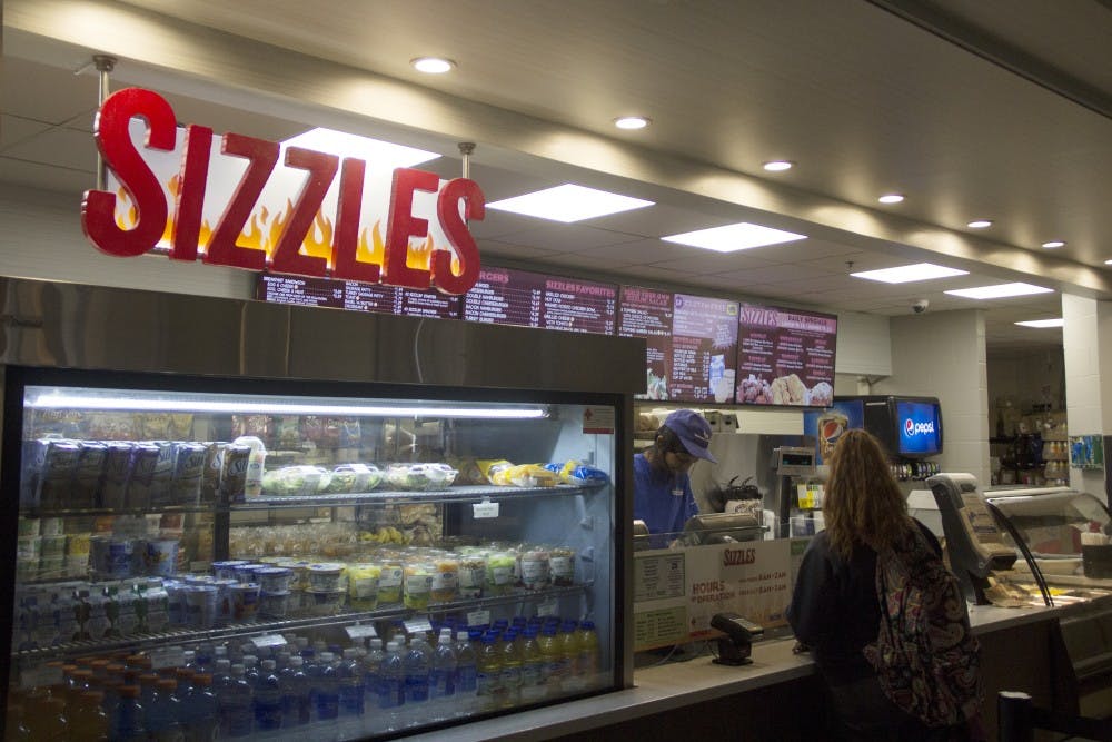 <p>Students wait in line for food at the Ellicott Food Court. A number of students are concerned with Campus Dining & Shops’ change to weekend meal credit acceptance at places like Hubie’s and Sizzles.</p>