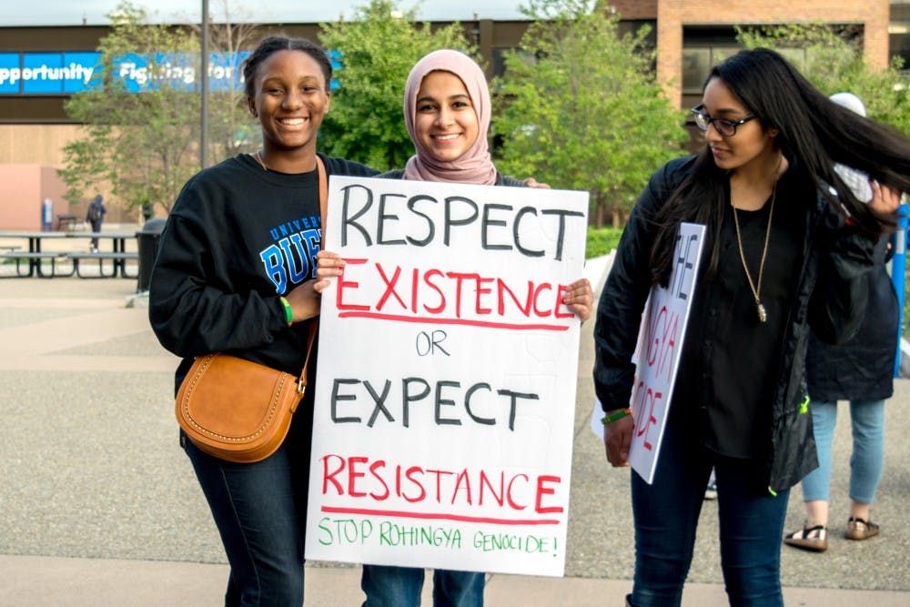 <p>Students participating in the Muslim Student Association's&nbsp;Walk with Us event hold a&nbsp;poster supporting Rohingya refugees.</p>