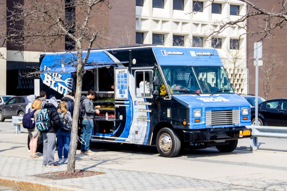 <p>Students standing in front of “Big Blue” food truck to order their lunch. The “Big Blue” and “Little Blue” food trucks are owned by the Faculty-Student Association and are the only trucks allowed to serve on UB’s campus.</p>