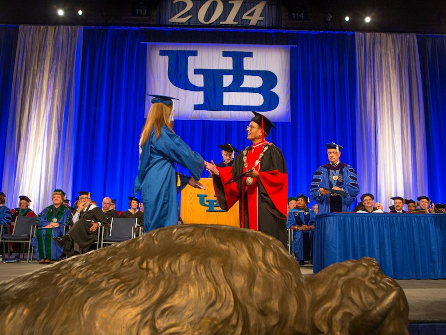 A student shakes&nbsp;UB President Satish Tripathi's hand during a graduation ceremony. Some students say walking at graduation symbolizes their hard work during college while others feel as though it is just a hassle.&nbsp;
