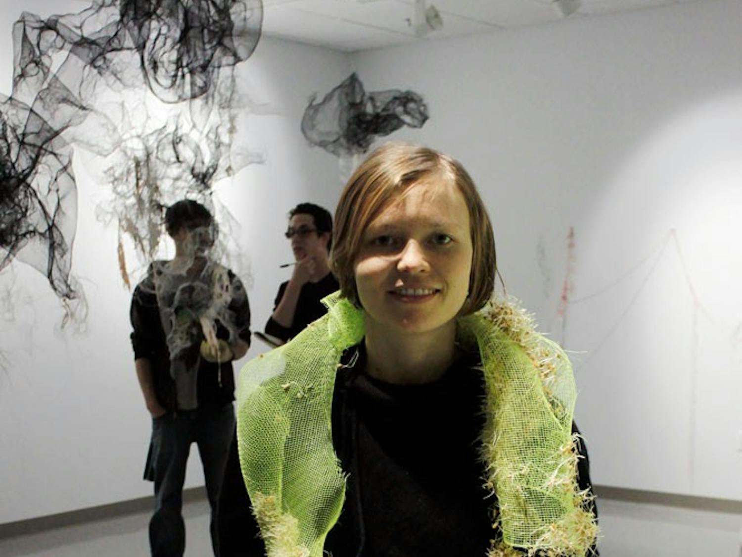 MFA student Liz Black showcased her eco friendly wearable art in her exhibit Creature Skin in the CFA. Black grew wheatgrass on gloves through the method of hydroponics.
