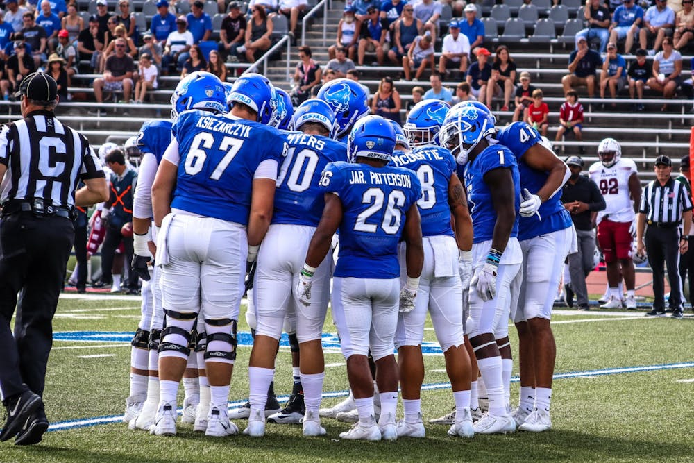 <p>The Bulls huddle for an offensive play at their own 20-yard line against the Temple Owls.</p>