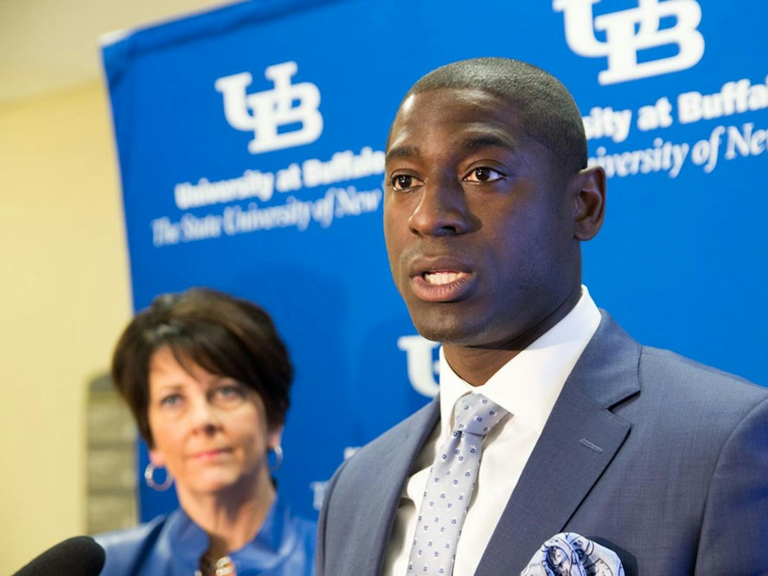 Athletic Director Allen Greene (front) speaks at Tuesday’s press conference in Capen Hall about UB Athletics’ new branding, as Nancy Paton (back), vice president of university communications, looks on. With a university-wide branding initiative, UB Athletics’ branding will no once again feature “Buffalo” prominently instead of “New York.”