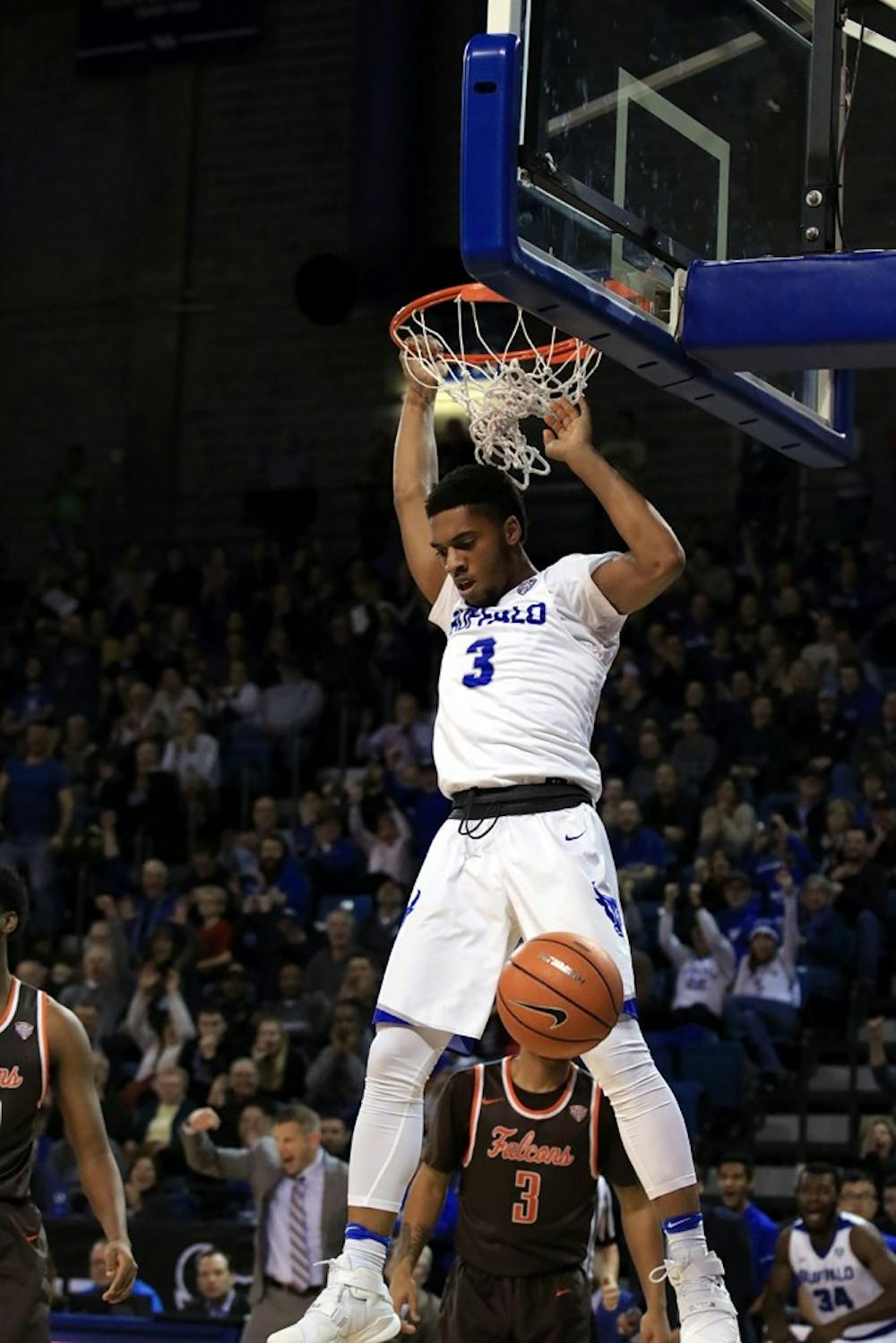 <p>Freshman guard Jayvon Graves hangs on the rim after a dunk. The Bulls became the outright MAC East champions on Friday.</p>