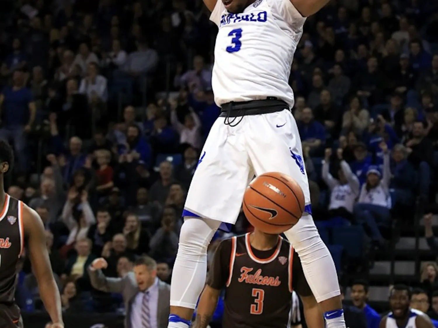 Freshman guard Jayvon Graves hangs on the rim after a dunk. The Bulls became the outright MAC East champions on Friday.