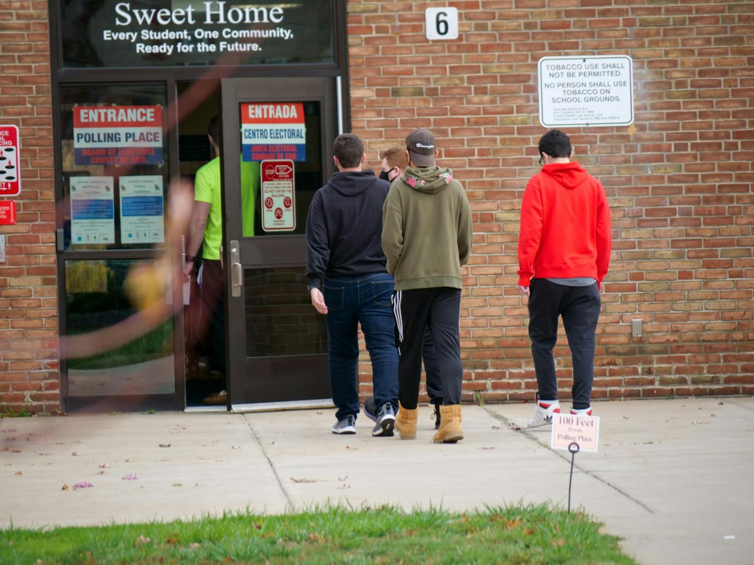 Young voters walking inside Sweet Home High School to cast their ballot for the 2020 election&nbsp;