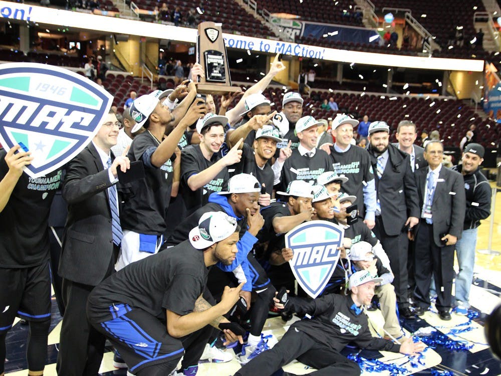 <p>The men’s basketball team and staff poses with the MAC Championship trophy and President Tripathi after their victory. The Bulls defeated Central Michigan 89-84 for the MAC title. - Angela Barca, The Spectrum</p>