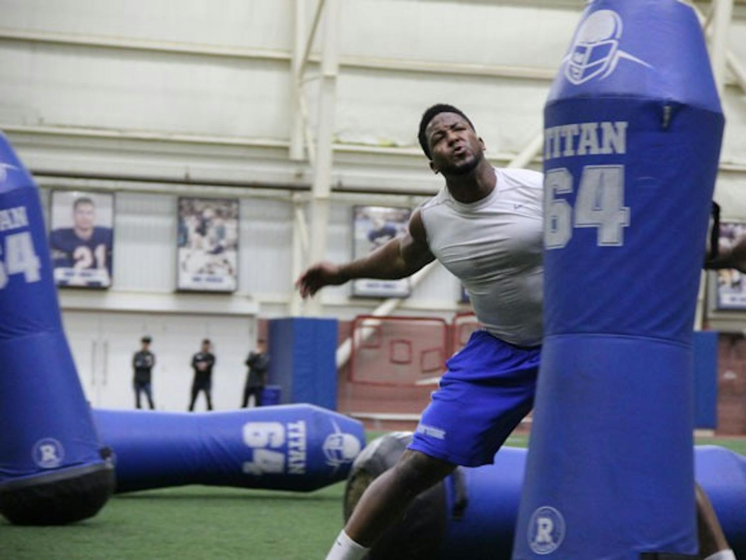 Tedroy Lynch, a graduated Bull, competes in a defensive drill, taking down tackle dummies.