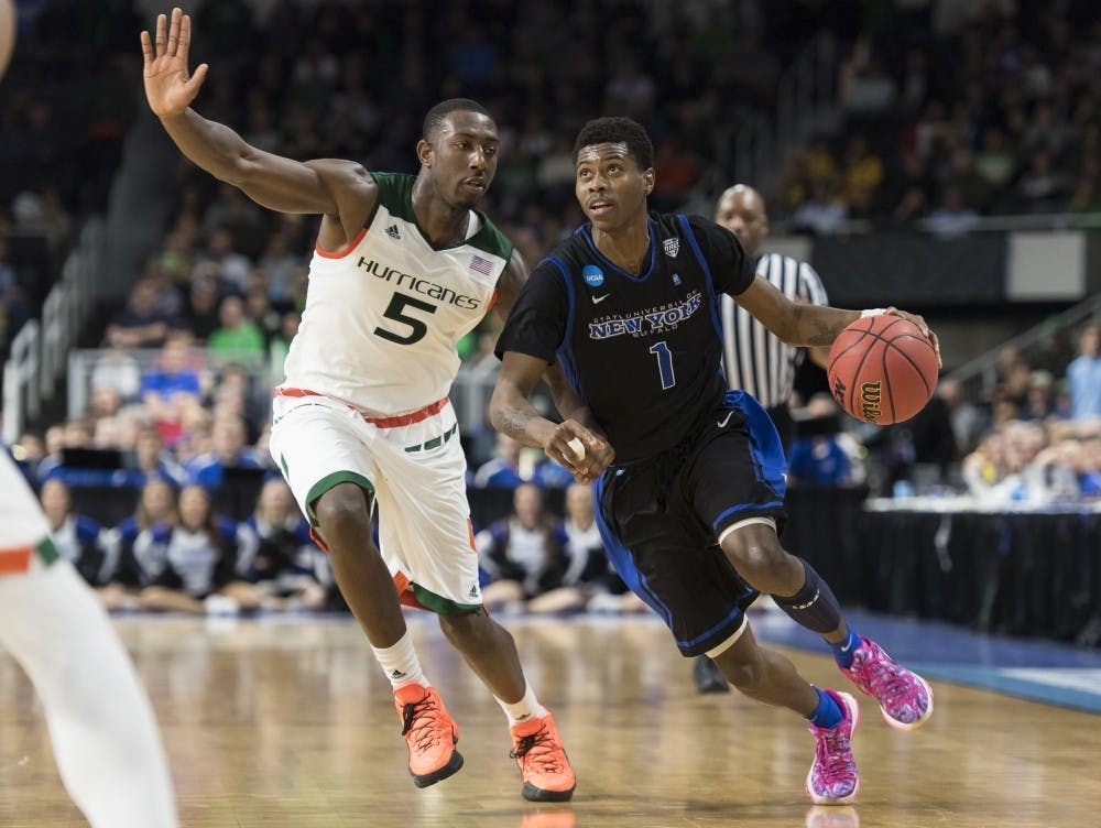 <p>Rising-junior guard Lamonte Bearden drives to the basket against Miami guard Devon Reed during Buffalo's 2016&nbsp;NCAA Tournament loss. Bearden is set to transfer from UB.</p>