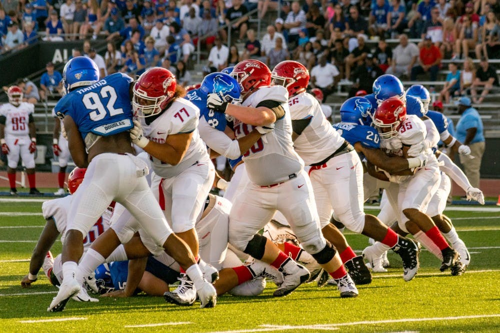 <p>Senior defensive end Chuck Harris tries to push through the Delaware State offensive line. The Bulls handily beat Delaware State 48-10 on Saturday.</p>