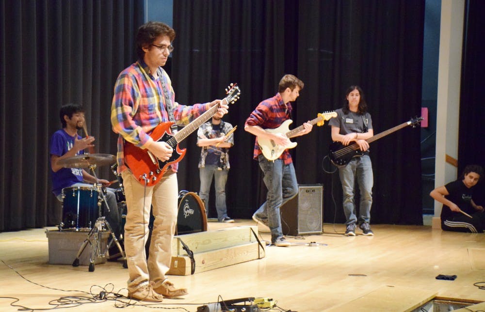 <p>Sophomore international business and finance student Jeremy Landau, pictured with other members of UB Jam Club, warms up his guitar at JAMPROV on Wednesday, December 2 at 6 PM in the SU Theater.</p>