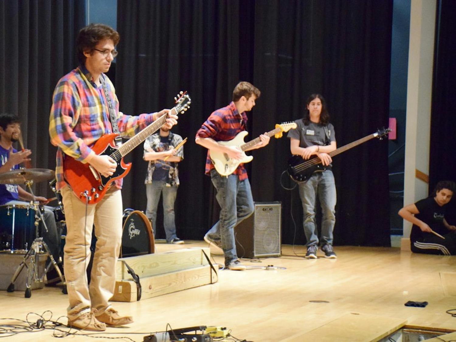 Sophomore international business and finance student Jeremy Landau, pictured with other members of UB Jam Club, warms up his guitar at JAMPROV on Wednesday, December 2 at 6 PM in the SU Theater.