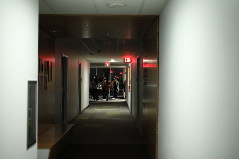 <p>Students walk through a hallway in Greiner Hall during a blackout.</p>