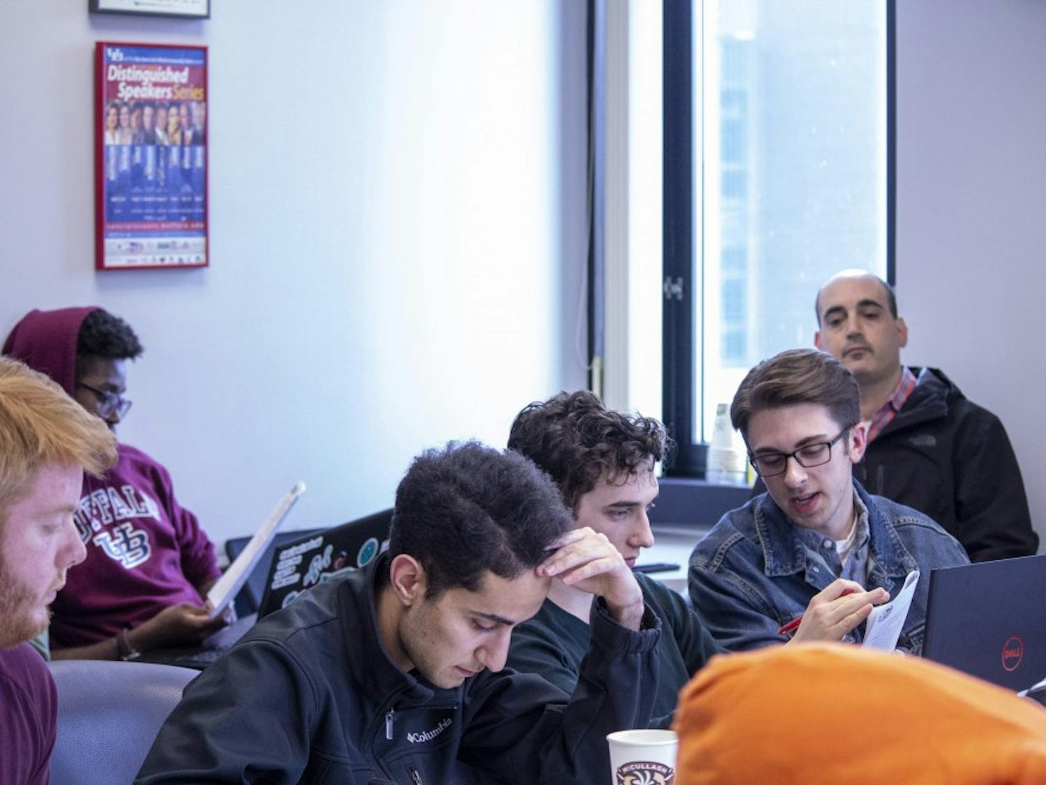 Student Association senators look over SA senate chairperson Eric Weinman’s proposed Rules of Procedures handbook at the Friday meeting.