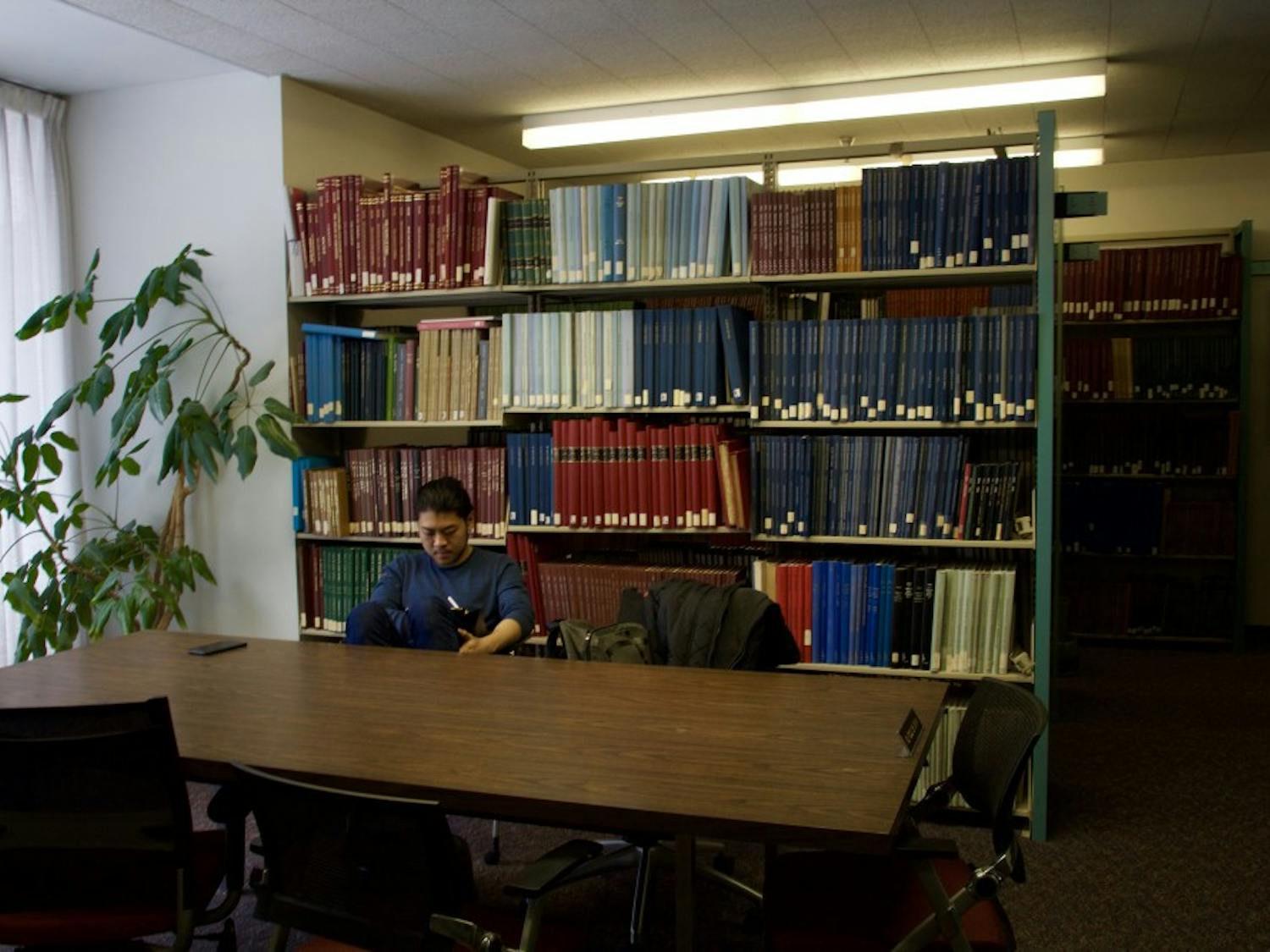 A student reads a book inside the Music Library alone. Faculty and students still have concerns over the library's future, following the retirement of the library’s archivist.
