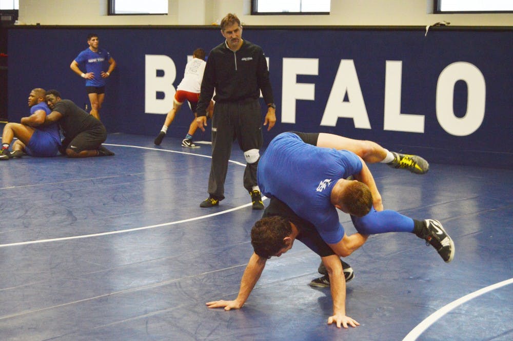 <p>Head coach John Stutzman overlooks a Bulls wrestler during practice as Buffalo prepares for the 2015-16 season.</p>