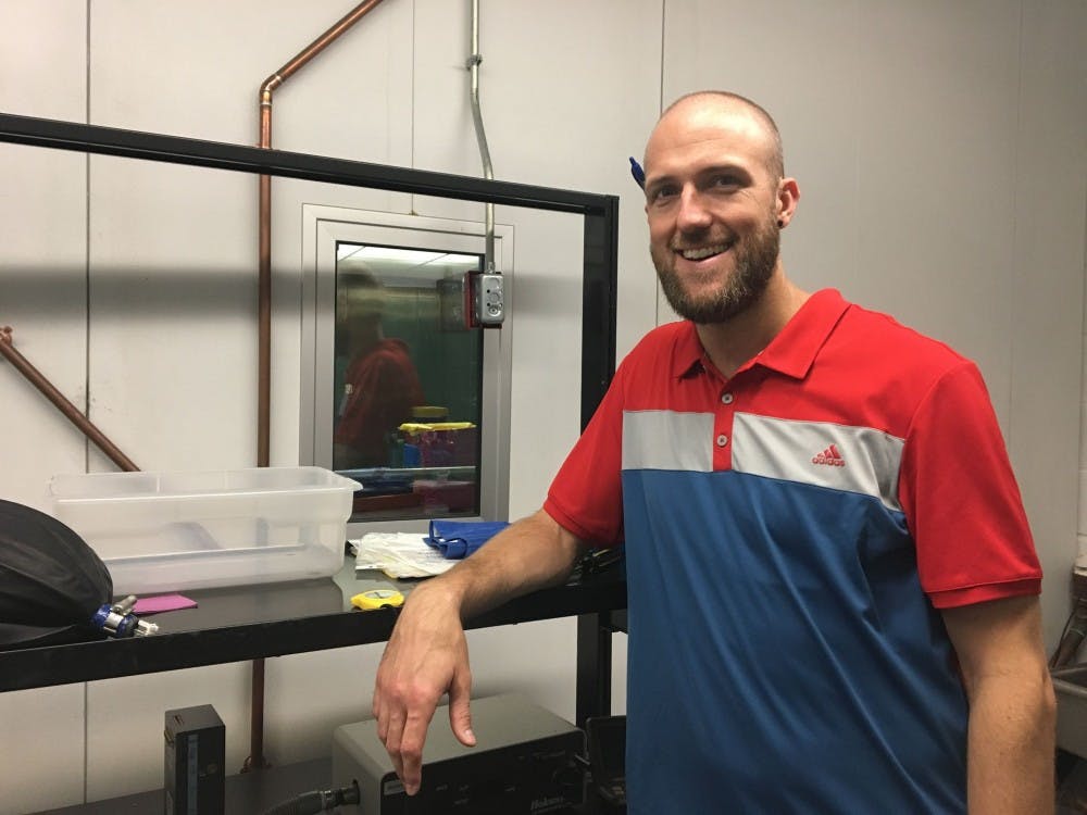 <p>Dr. Zachary Schlader stands in front of a temperature-controlled room that he uses in many of his studies. Schlader, an assistant professor in the department of exercise and nutrition sciences, conducts research on exercise physiology, behavior and thermoregulation.</p>