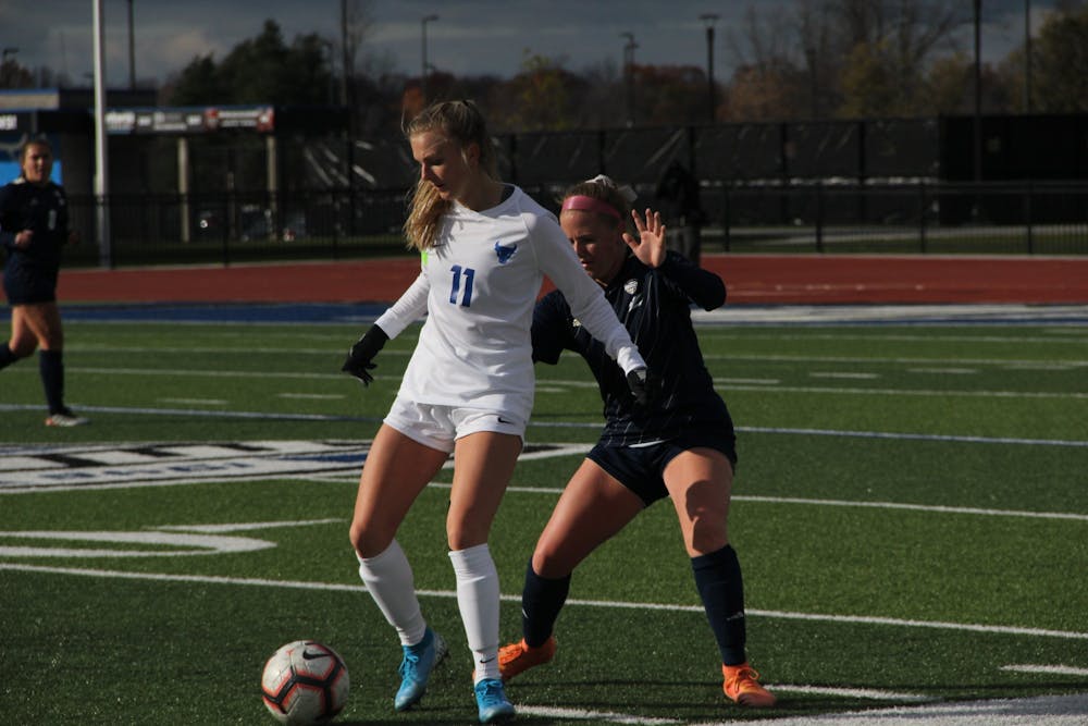 UB midfielder Marcy Barberic (11) defends the ball from Akron during the 2019 MAC Quarterfinals.