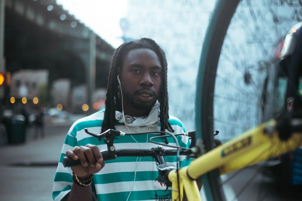 <p>Buffalo rapper Billie Essco poses with a bicycle.</p>