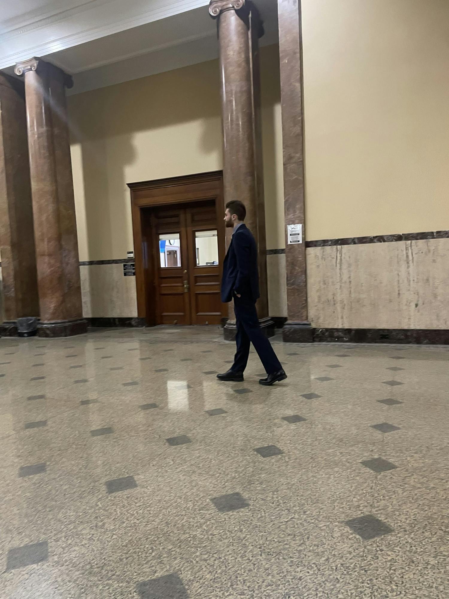 Jacob Cassidy, president of UB's Young Americans for Freedoms chapter, paces outside of the courtroom door Tuesday morning prior to a hearing that had extended his firearms ban until Nov. 24. 