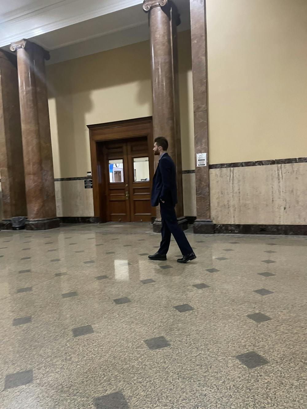 Jacob Cassidy, president of UB's Young Americans for Freedoms chapter, paces outside of the courtroom door Tuesday morning prior to a hearing that had extended his firearms ban until Nov. 24. 