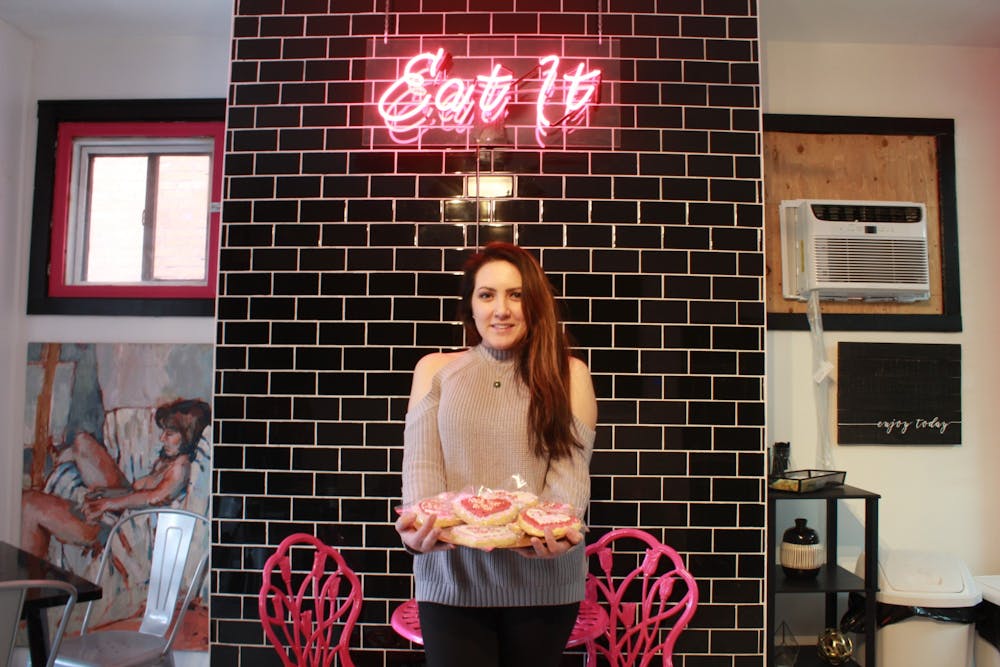 <p>Mundy Cakes owner Amanda Bernardini poses with cookies inside Mundy Cakes on Allen Street.</p>