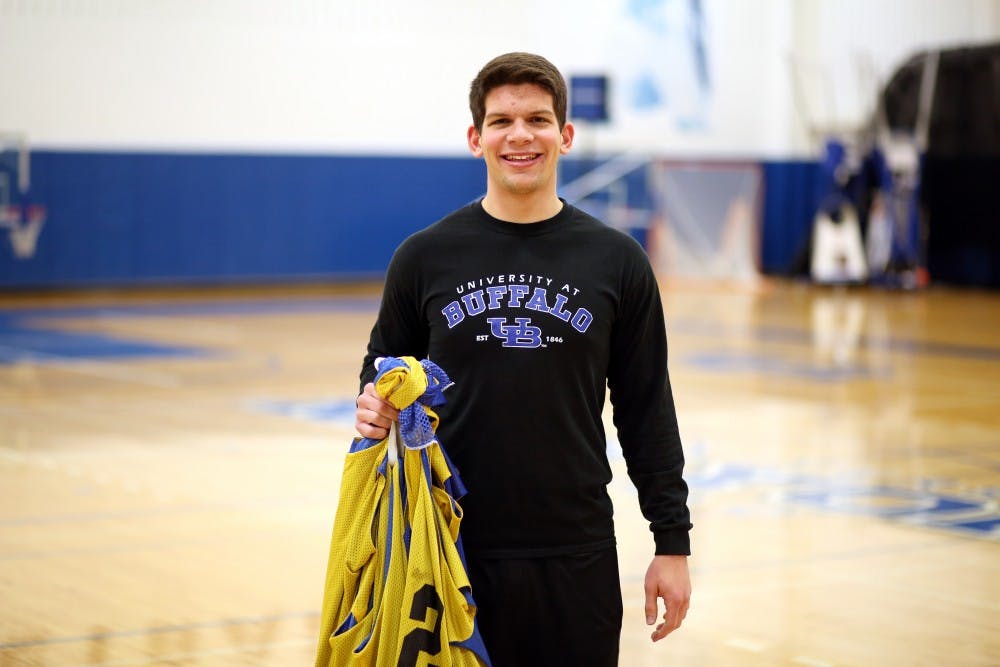 <p>Men's basketball head manager Wesley Scheier stands center court holding practice jerseys. Scheier handles many important tasks, including feeding the team.</p>