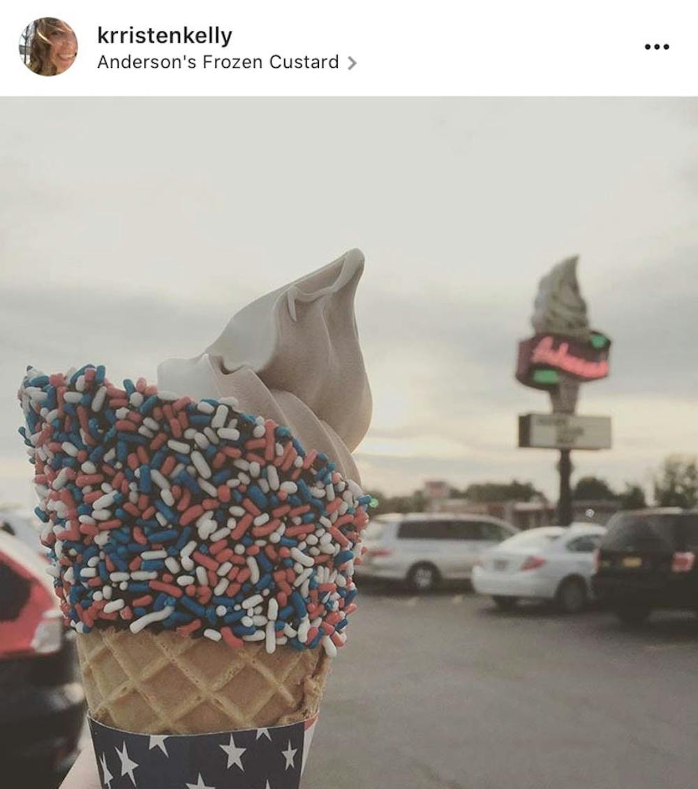 <p>Lemaster holds her dipped waffle cone in front of the old-fashioned Anderson’s sign.</p>