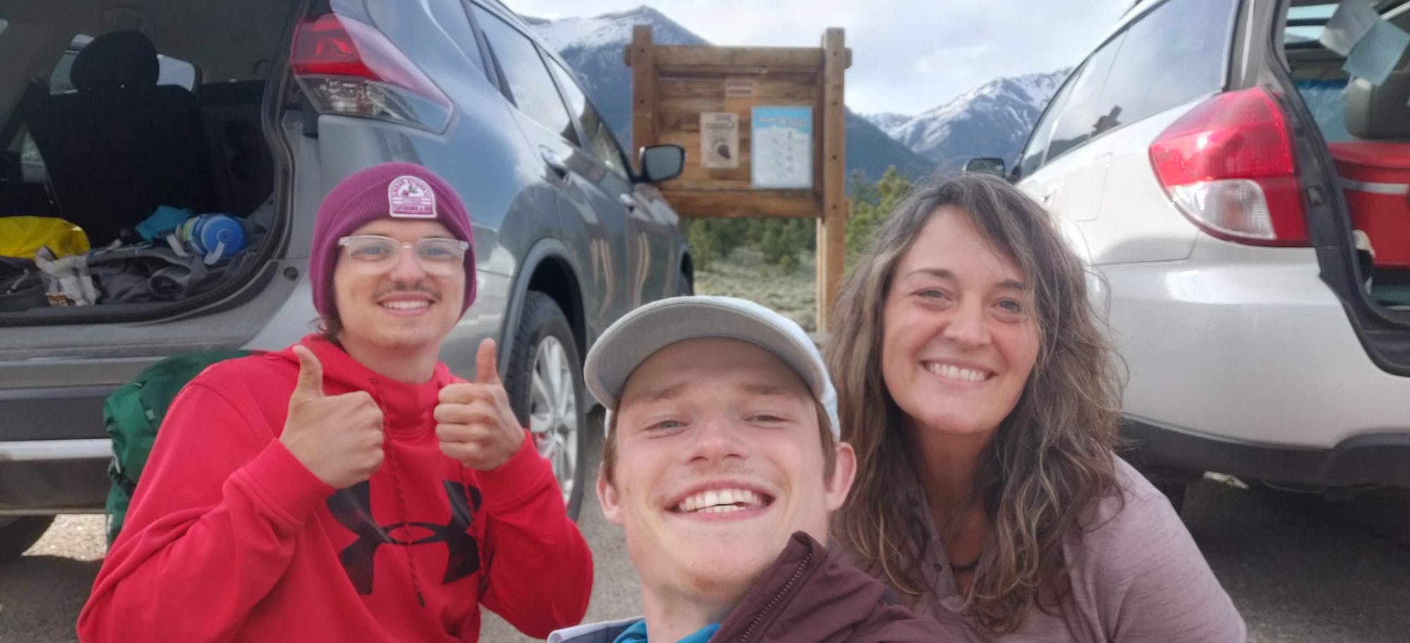 Collin Searles (left) and Nick Metz (center) pose with an unknown woman at a trail head.