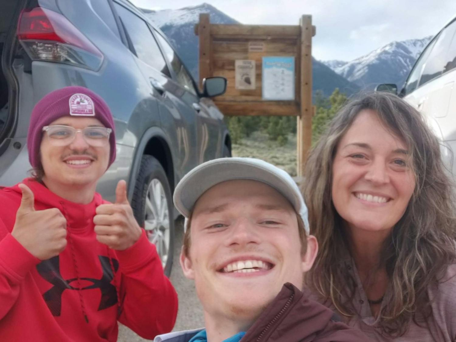 Collin Searles (left) and Nick Metz (center) pose with an unknown woman at a trail head.