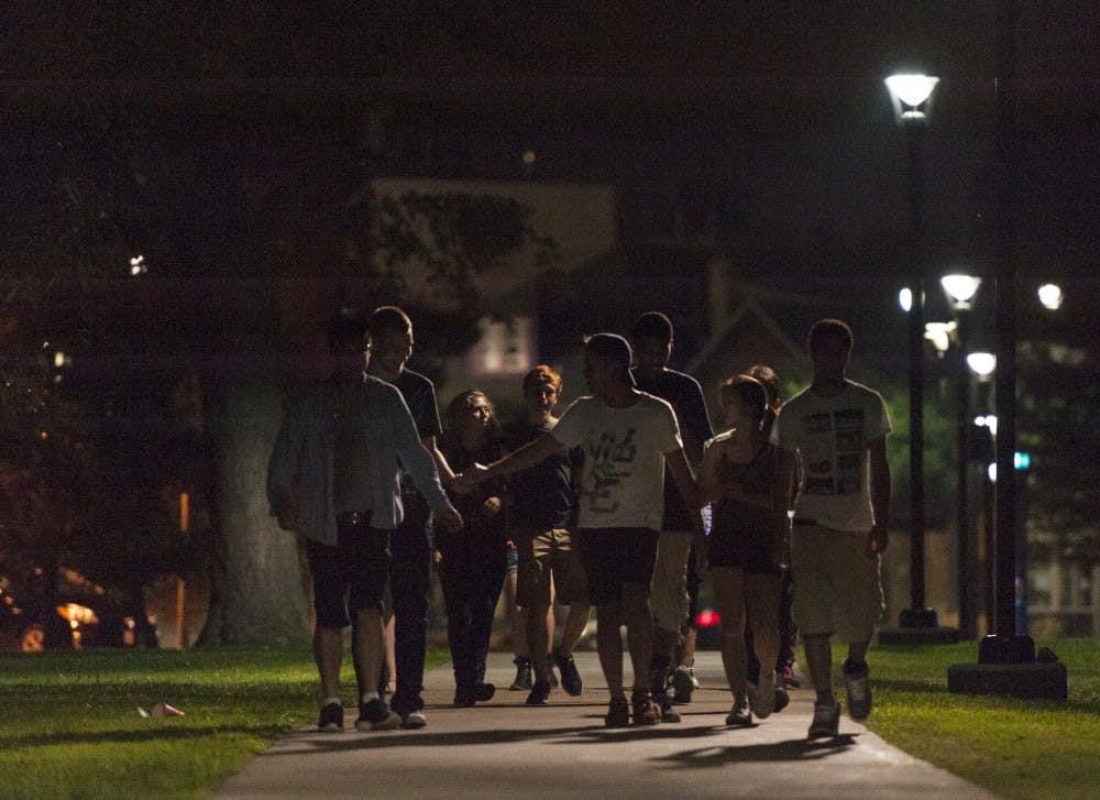 <p>Students walk to the South Campus bus loop after a night in the Heights. </p>
