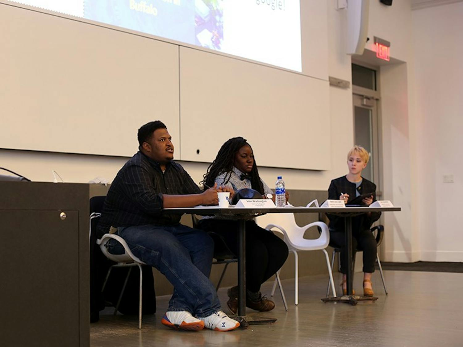 Panelists John Washington (left) and Jessica Coley (middle) discuss concerns on how the university’s three campuses are impacting Buffalo neighborhood.&nbsp;The panelists’ speeches were followed by a Q&A, where the crowd asked questions about the way the university’s campuses are impacting the surrounding neighborhoods.