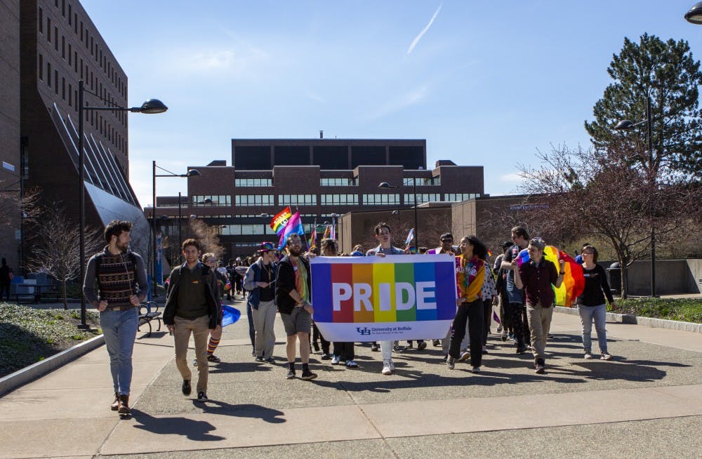 <p>UB students march on the Academic Spine of North Campus for UB’s LGBTQ Pride Parade on Wednesday. Students ended the march at the SU, where they continued with a pride festival.</p>