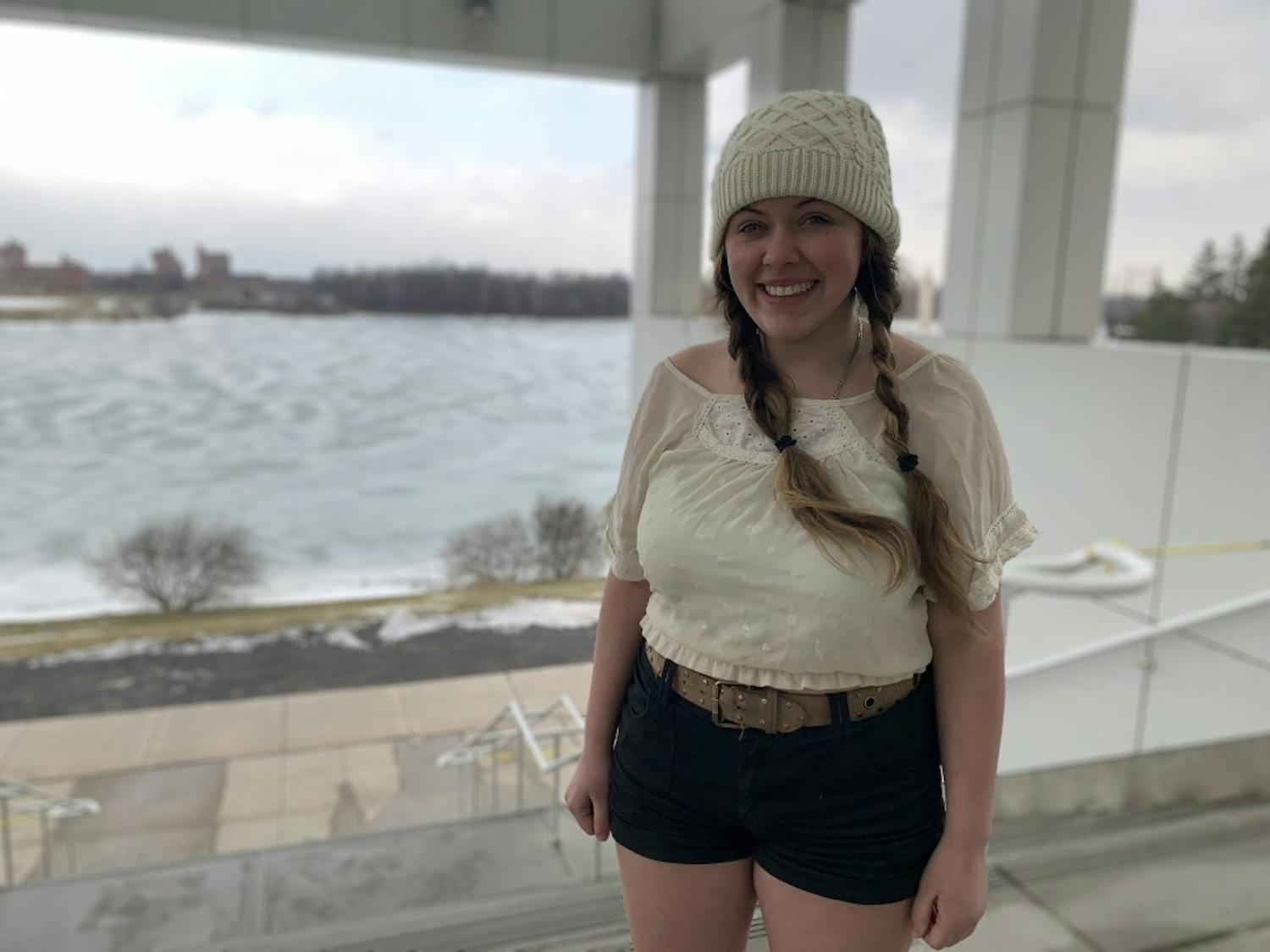 Anna Seidl stands in front of ice-covered Lake LaSalle. The theater performance student has built a local reputation for wearing shorts during the winter.