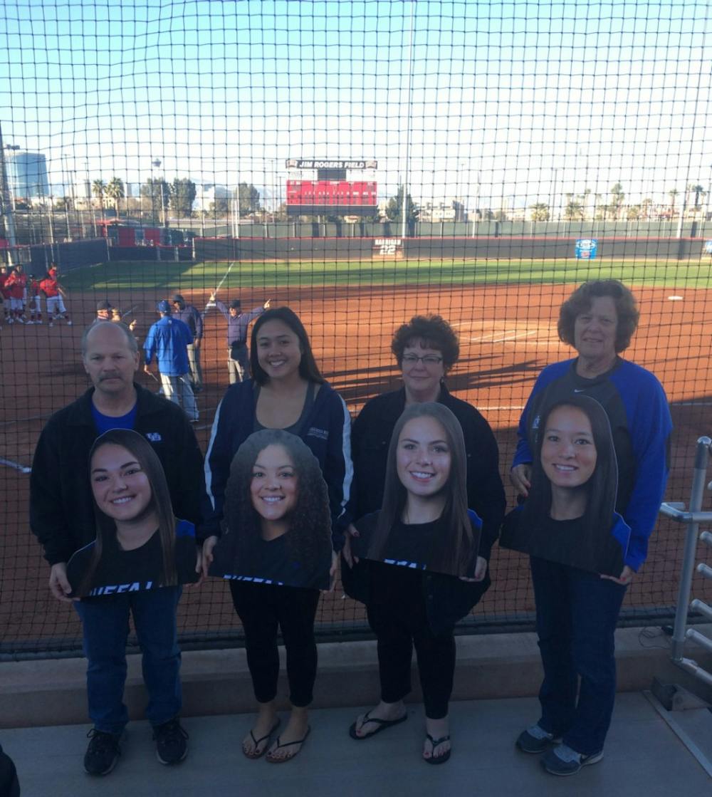 <p>Softball family members hold up cutouts of senior players. Laureen Jacobs (second from right) holds up her daughter and senior infielder Nicolette Jacobs’ image.&nbsp;</p>